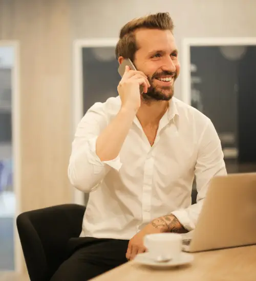 A smiling person talking on a phone.